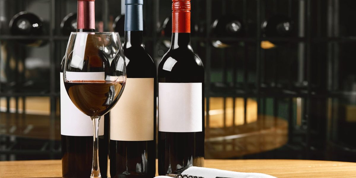 Bottles and glasses with wine on the table. Wine drinking culture concept. Apperetes and survivors. Copy space, dark background.